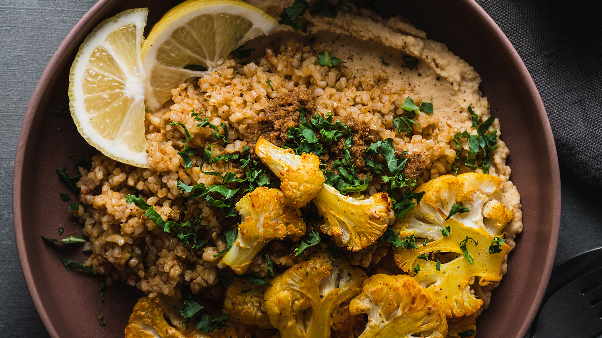 Bowl di Bulgur al pesto rosso, cavolfiore speziato e hummus di ceci