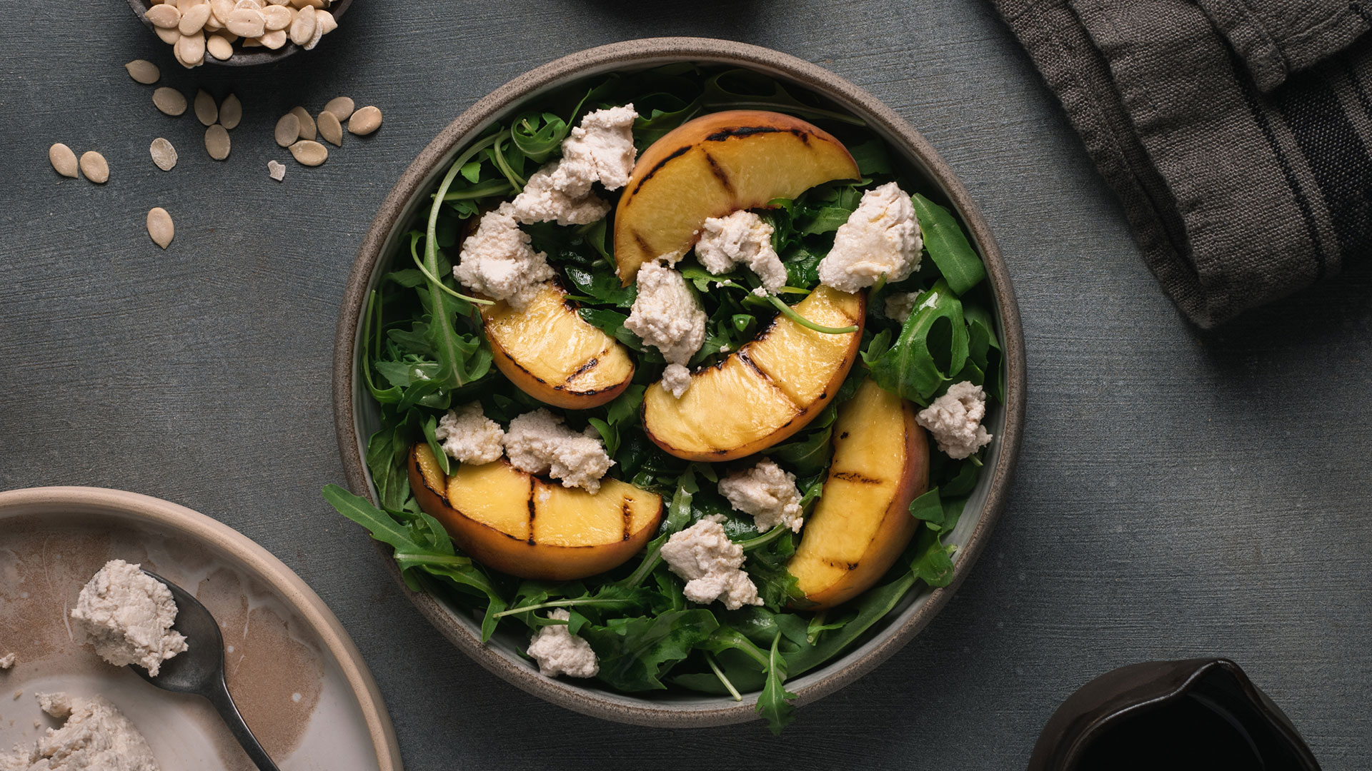 Insalata di rucola, pesche grigliate e ricotta di semi di anguria